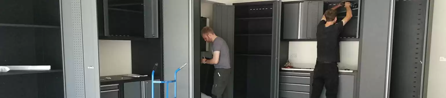 Fitters carrying out an installation of garage cupboards and worktops